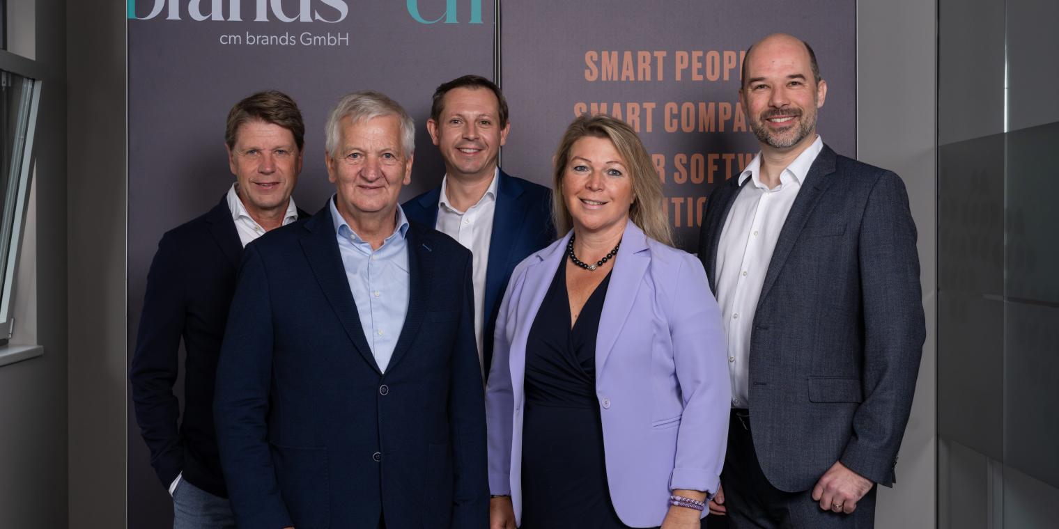Geschäftsführungsteam vor Unternehmenslogo S2 – Sm@rter Software Engineering & Consulting GmbH