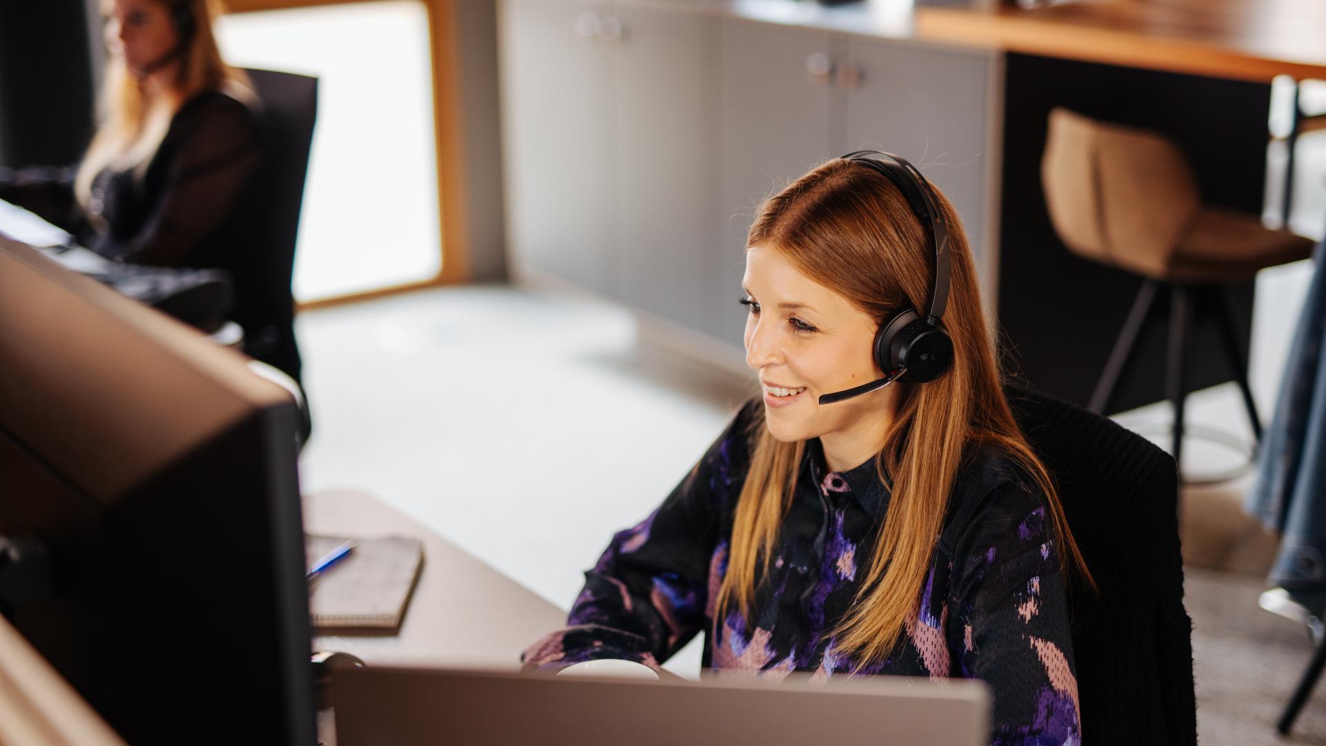 Team Smarter Software | © Daniel Waschnig Photography Zwei Frauen sitzen mit Headset vor dem Computer