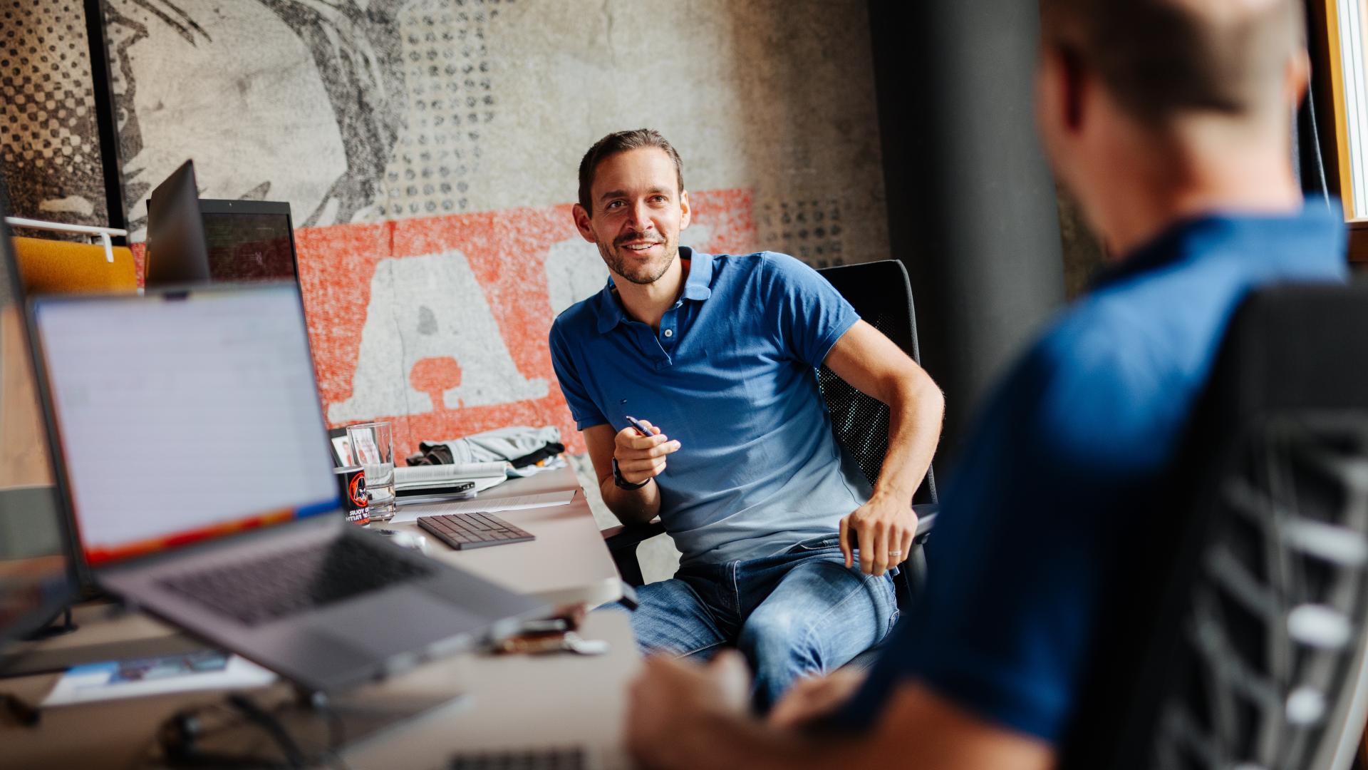 Marcel Ring, Smarter Software | © Daniel Waschnig Photography Marcel Ring sizt mit einer anderen Person bei einem Schreibtisch